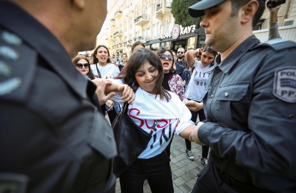 A women’s rights protester is detained by police in Baku on October 20. 