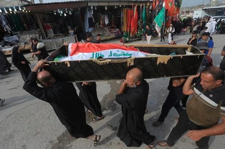 Des hommes transportent un cercueil ouvert dans lequel gît le corps, recouvert du drapeau irakien, d’un manifestant tué à Najaf le 8 octobre 2019. 