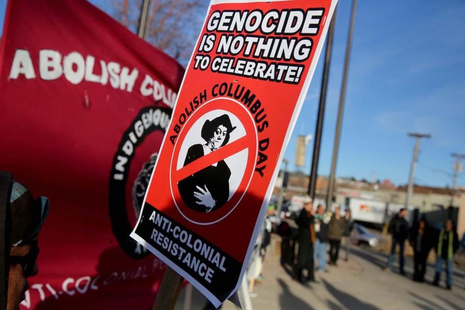 Signs calling for the abolition of Columbus Day stating Genocide is Nothing to Celebrate