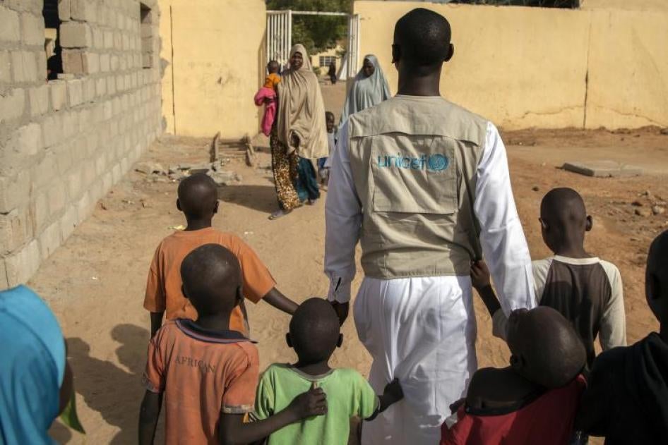 Un employé de l’UNICEF accompagnait plusieurs jeunes garçons lors de leur libération de détention militaire au Nigeria, en juillet 2018.