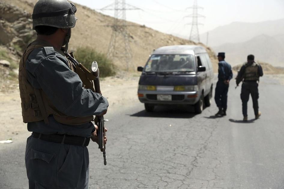 Afghan police officers search a vehicle at a checkpoint on the Ghazni highway, in Maidan Shar, west of Kabul, Afghanistan, Monday, Aug. 13, 2018.