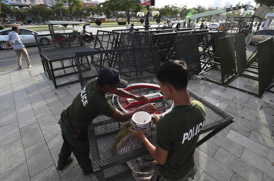 Police officers paint on barricades at the park near the residence of Cambodian's Prime Minister Hun Sen in the preparation for Saturday's Independent Day event, in Phnom Penh, Cambodia, Tuesday, Nov. 5, 2019. 