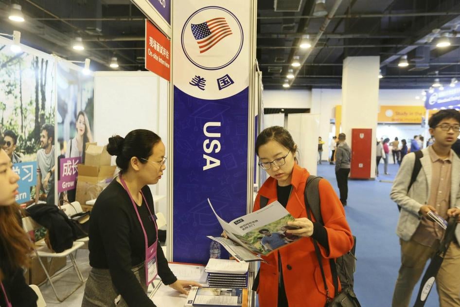 Chinese visitors talk with education consultants at the booth of the United States during an expo in Beijing, China, 20 October 2018.