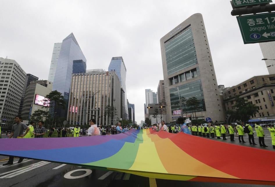 Participants march with a rainbow flag during a gay pride parade in Seoul