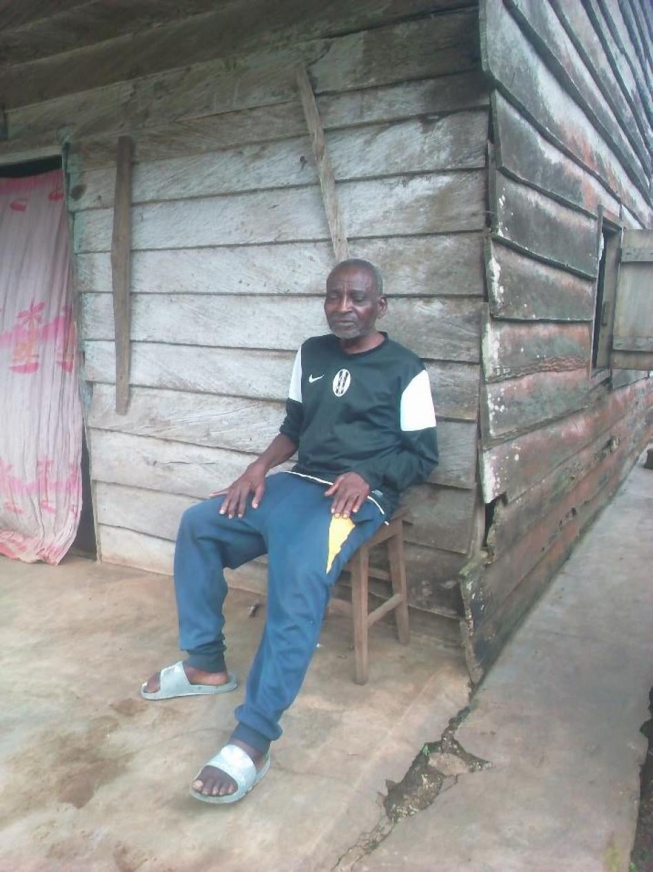 Chrispu, un homme aveugle de 75 ans avec un problème de santé mentale et un handicap physique, devant sa maison à Ekona, dans la région du Sud-Ouest.