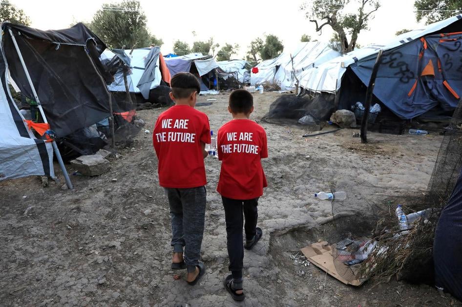 Deux garçons marchent dans un camp de fortune situé près du camp pour réfugiés et migrants à Moria sur l’île de Lesbos en Grèce, le 17 septembre 2018.