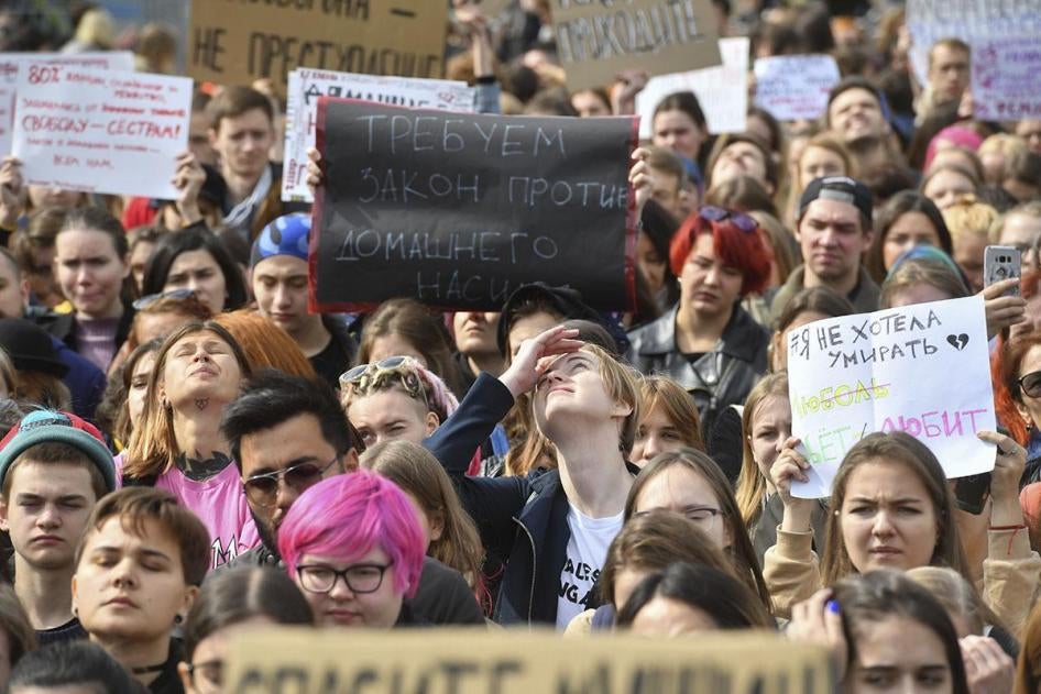A participant's sign reads "We demand a law against domestic violence" during a rally in support of Kristina, Angelina and Maria Khachaturyan, accused of killing their abusive father, in St. Petersburg, Russia.