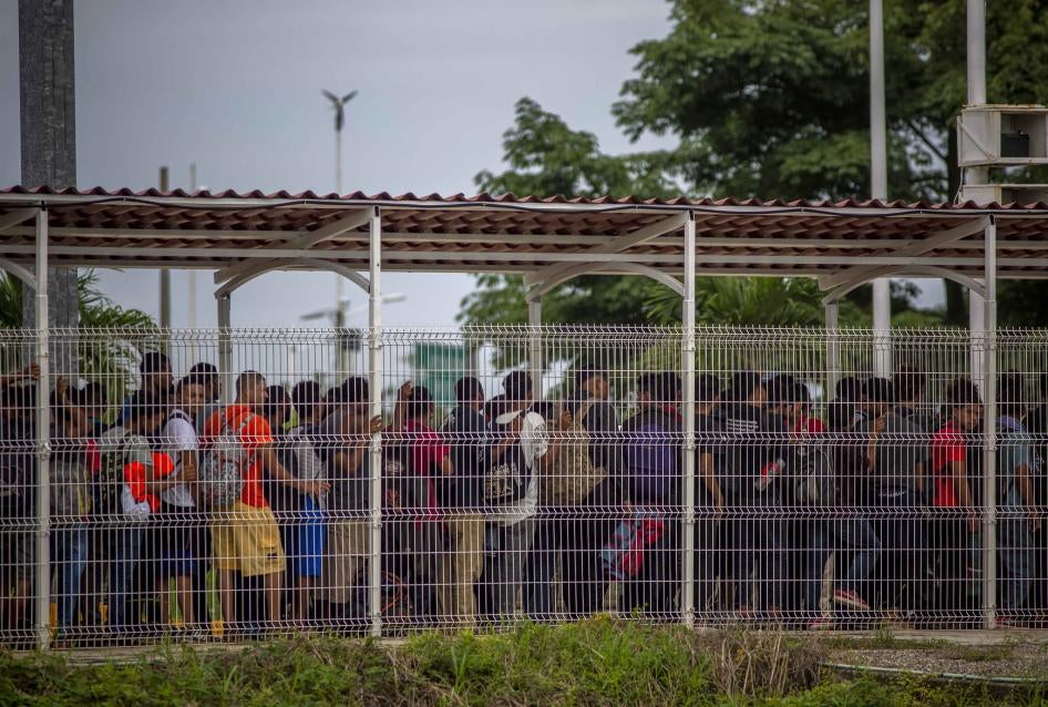 Las autoridades mexicanas guían a los migrantes a través del cruce fronterizo El Ceibo entre Guatemala y México el 19 de enero de 2020.