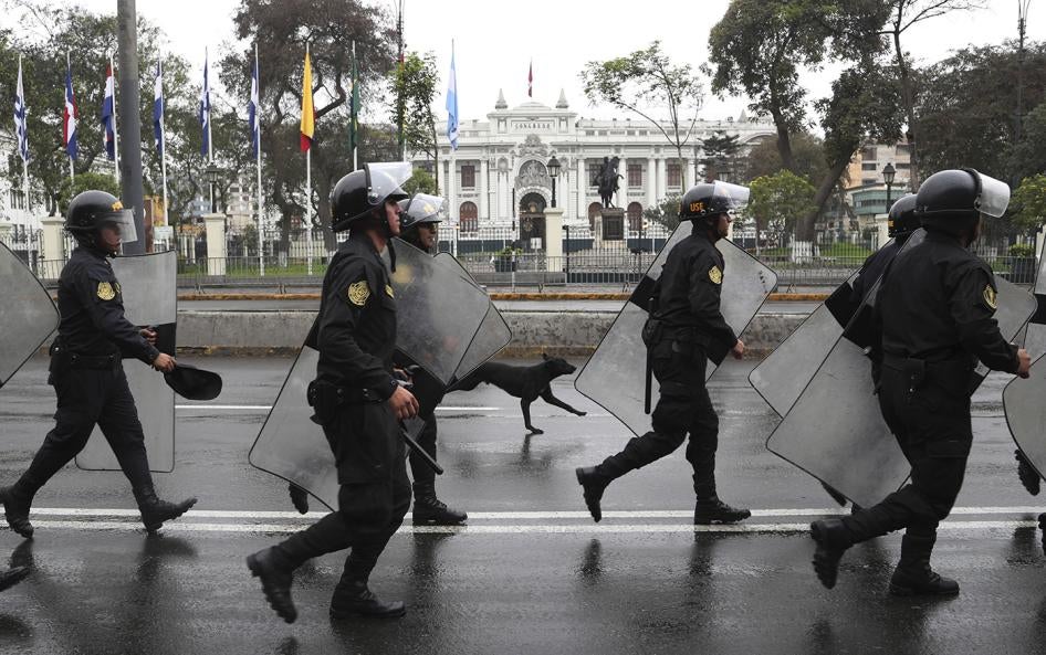 Riot police walk in front of the closed congress building in Lima, Peru, Tuesday, Oct. 1, 2019. 