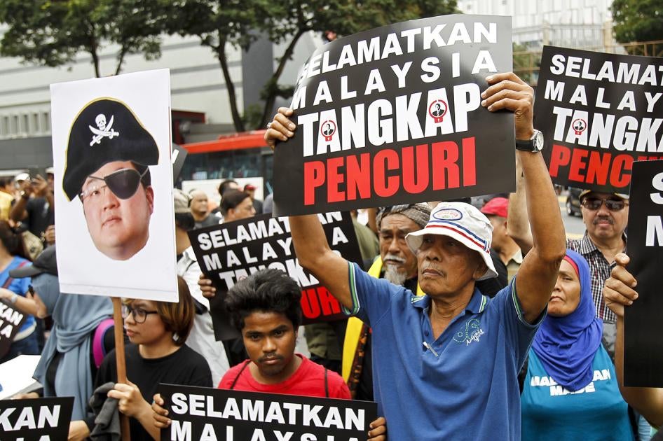 Protesters hold placards reading " Save Malaysia, Arrest the Thief " during a protest in Kuala Lumpur, Malaysia, Saturday, April 14, 2018. 