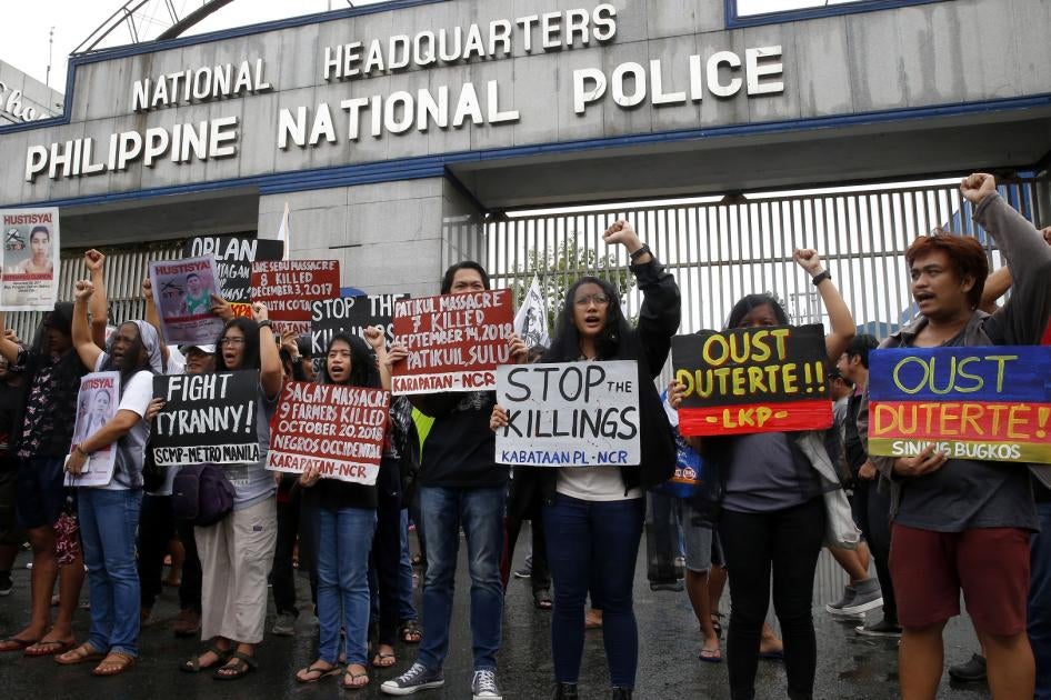 Manifestantes cubiertos con velo, en su mayoría familiares de víctimas de presuntas ejecuciones extrajudiciales, exhiben pancartas durante una protesta frente a los campamentos militares y policiales filipinos en Quezon City, Filipinas, el miércoles 17 de