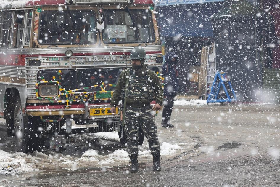An Indian paramilitary soldier stands guard as snow falls in Srinagar, Kashmir, January 15, 2020.
