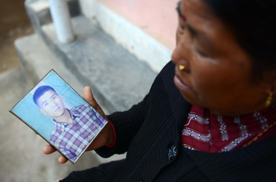 In this photograph taken on February 2, 2017, Nepalese war victim Pabitra Sunakhari shows a photograph of her son as she speaks during an interview with AFP in Birendranagar, Surkhet District, some 520kms west of Kathmandu