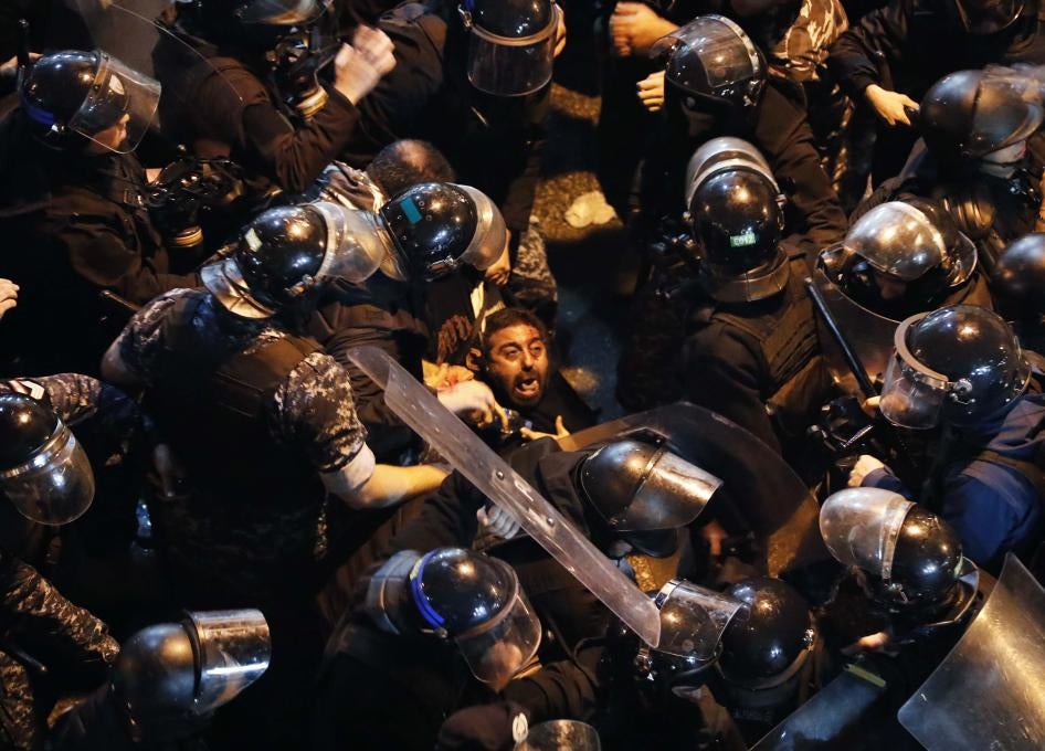 Riot police arrest a protester outside a police station in Beirut, Lebanon on Wednesday, January 15, 2020.