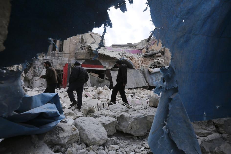 Trois hommes marchent parmi les décombres près d’un immeuble gravement endommagé par une frappe aérienne menée par les forces du gouvernementales à Ariha, dans la province d'Idlib, en Syrie, le 15 janvier 2020.