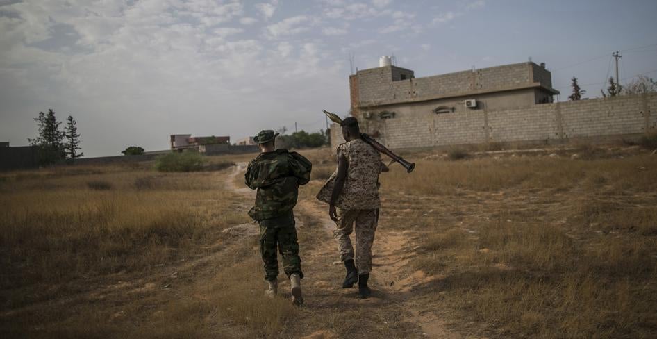 Deux combattants du Gouvernement d'union nationale basé à Tripoli, dans le nord-ouest de la Libye, avancent vers la caserne d'Al-Yarmouk, le 29 août 2019. Les forces gouvernementales ont combattu les forces de l'Armée nationale libyenne (autoproclamée) ba
