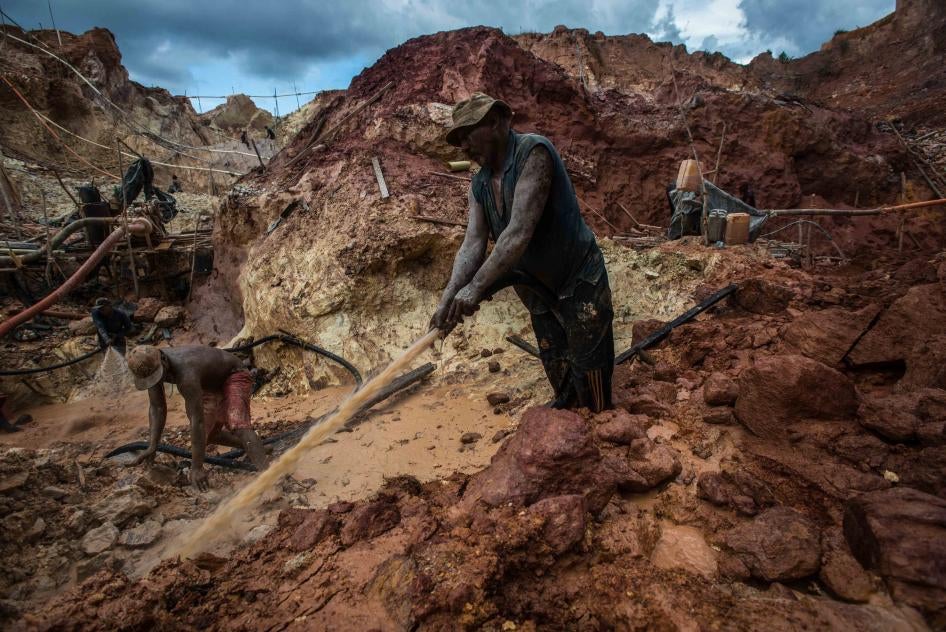 Deux hommes souillés de boue travaillent dans une mine d’or illégale à Las Claritas, dans l’État de Bolivar au Venezuela, le 20 juillet 2016. Cette mine était alors déjà surnommée « Mina Cuatro Muertos » («  Mine des quatre morts ») en raison des décès de