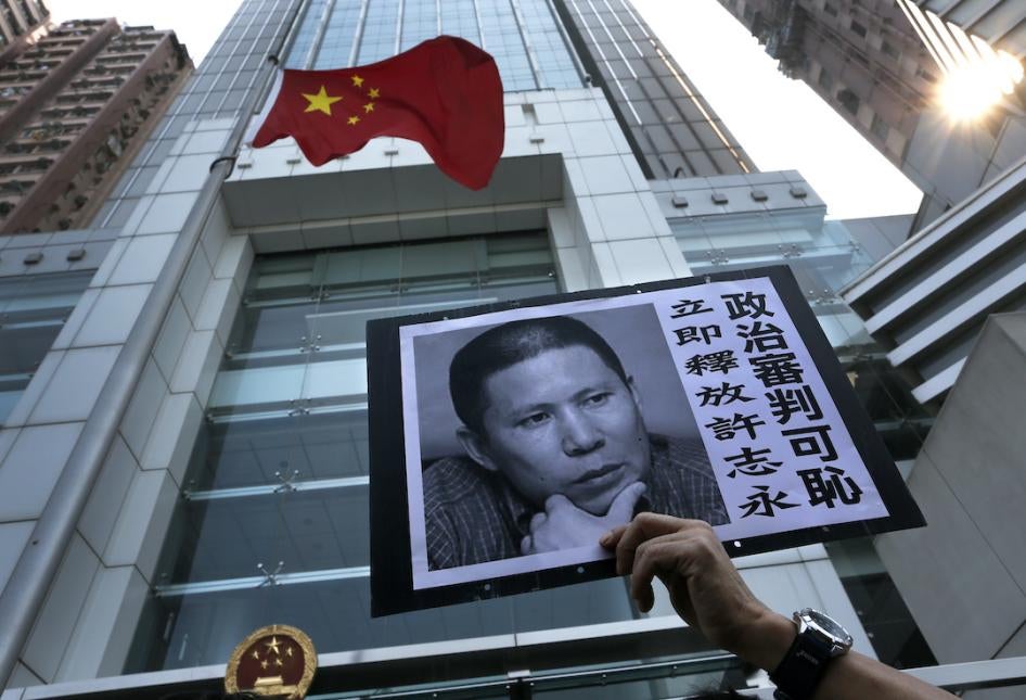A demonstrator raises a poster of Xu Zhiyong during a protest against his sentencing, Hong Kong, January 27, 2014.