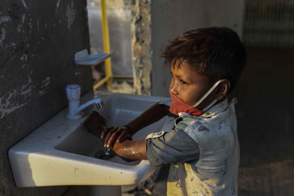 Un enfant se lave les mains avec du savon désinfectant bactéricide, comme mesure préventive contre le COVID-19, au Terminal maritime Sadarghat à Dacca, au Bangladesh, le 27 mars 2020. 