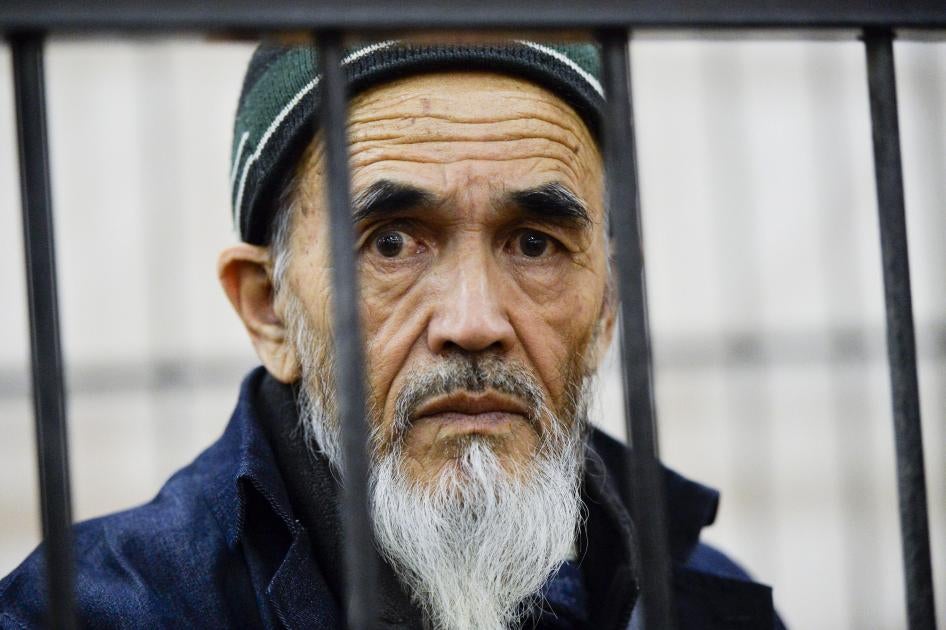Ethnic Uzbek journalist Azimzhan Askarov, who was arbitrarily arrested, tortured, convicted after an unfair trial and jailed for life looks through metal bars during hearings at the Bishkek regional court, Kyrgyzstan.