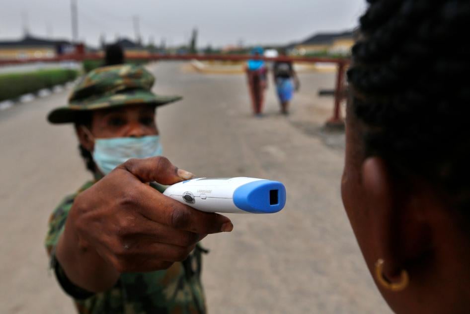 A member of the Nigerian army performs a temperature check on a visitor at the entrance of the Nigerian Army Hospital in the Yaba area of Lagos, Nigeria, February 28, 2020.