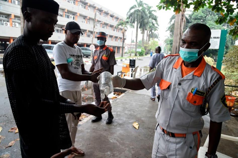 A securityman administers sanitiser to a visitor to a state hospital in Lagos, on February 28, 2020. 