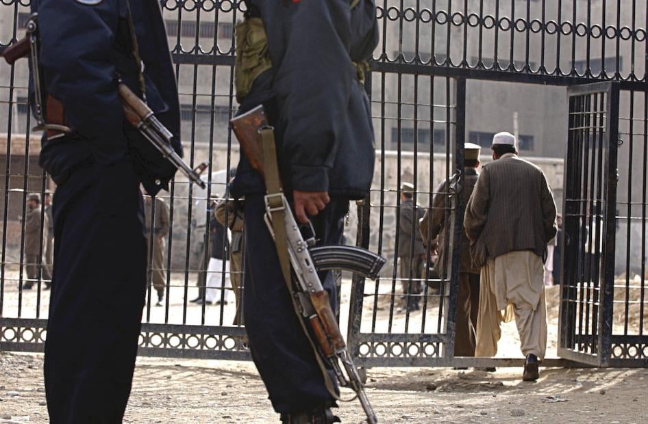 Officers stand guard in front of the Pul-e Charkhi prison's gate in Kabul