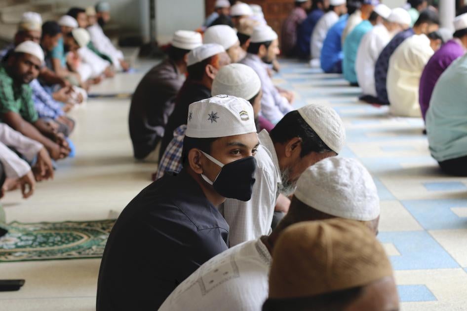 Muslims wear protective masks while offering Friday prayers