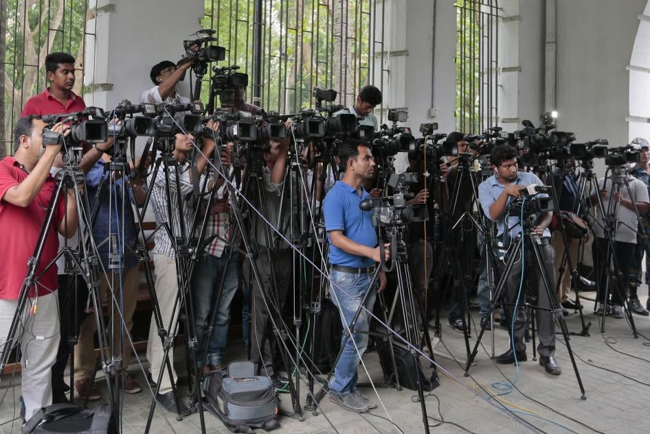 In this May 3, 2016 file photo, Bangladeshi journalists cover proceedings outside a court in Dhaka, Bangladesh. 