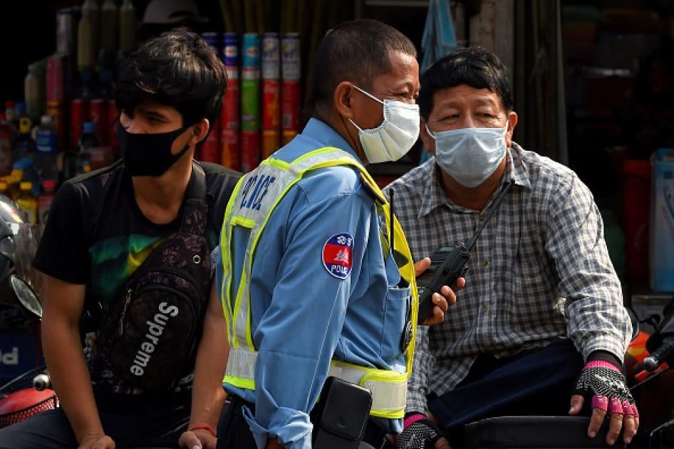 警察（中）和市民都戴上口罩，防范新冠病毒，柬埔寨金边，2020年3月17日。