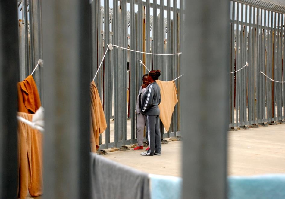 Deux migrantes photographiées près de la barrière de clôture du centre de rétention de Ponte Galeria, dans la banlieue de Rome, le 6 mai 2017.