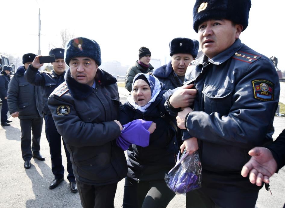 Кыргызские милиционеры задерживают активистку женского правозащитного движения "Femen" на площади Победы во время празднования Международного женского дня в Бишкеке в воскресенье, 8 марта 2020 года.