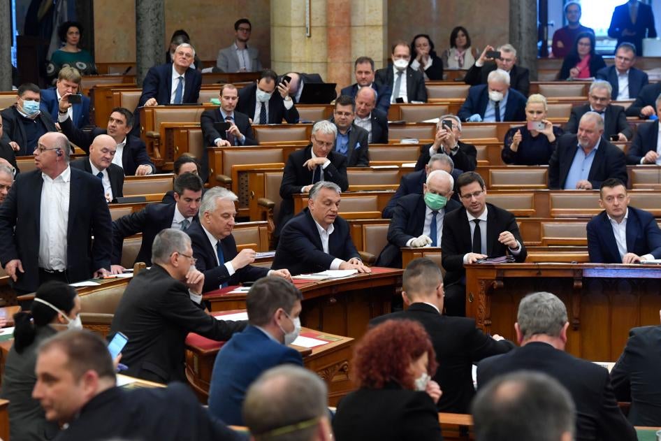 Le Premier ministre hongrois Viktor Orban, au centre, son adjoint Zsolt Semjen, d'autres membres du gouvernement et des députés du parti au pouvoir Fidesz votent sur un projet de loi concernant des mesures extraordinaires au cours de la session plénière d