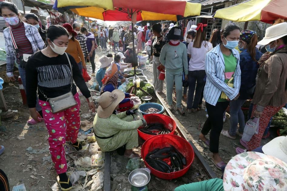 Des employées d’une usine de confection font leurs courses à la fin de leur quart de travail, dans une ruelle bondée dans la banlieue de Phnom Penh, au Cambodge, le 20 mars 2020.