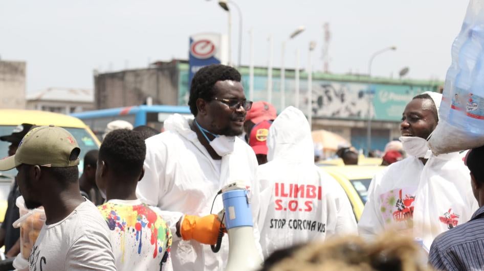 Des activistes du mouvement pro-démocratie Filimbi sensibilisent la population à la pandémie de COVID-19, au marché Gambela de Kinshasa, en République démocratique du Congo, le 28 mars 2020.