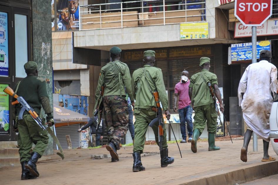 Ugandan police and other security forces chase people off the streets, after police cleared a stand of motorcycle taxis which are no longer permitted to operate after all public transport was banned for two weeks to halt the spread of the new coronavirus,