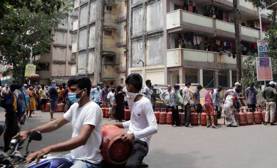 भारत के मुंबई में अपने-अपने रसोई गैस सिलेंडर की रिफिलिंग के लिए कतार में खड़े लोग, 26 मार्च, 2020 © 2020 एपी फोटो/रजनीश ककाडे