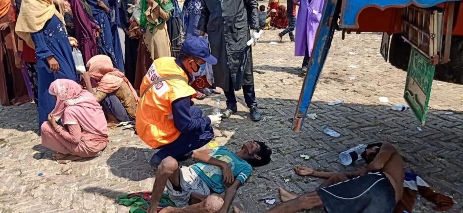 A screenshot of an exhausted Rohingya refugee receiving aid from the Bangladeshi coast guard. ©2020 Bangladeshi Coast Guard/Facebook
