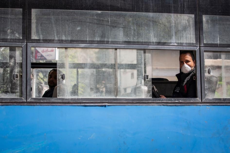 رجلا يرتدي كمامة على متن حافلة شبه فارغة في القاهرة، مصر، في 30 مارس/آذار 2020. 