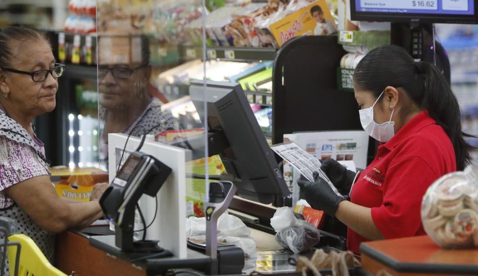 Grocery store cashier wears a mask while working