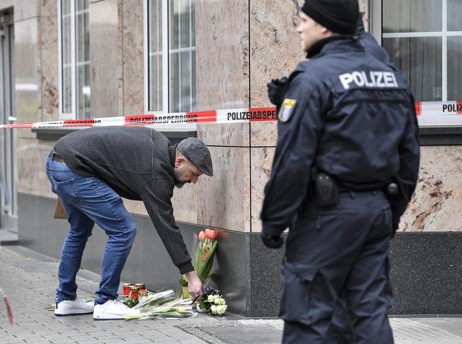 A man places flowers near a shisha bar where several people were killed on Wednesday night in Hanau, Germany, Thursday, Feb. 20, 2020.
