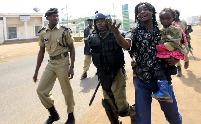 Police arrest a man with a child in a suburb of Kampala on September 11, 2009.