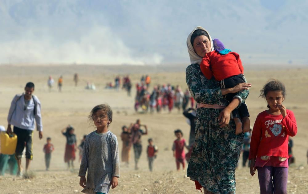 Des membres de la minorité yézidie fuyant la ville de Sinjar, dans le nord de l'Irak, face à l'avancée des combattants de l'État islamique, en août 2014.