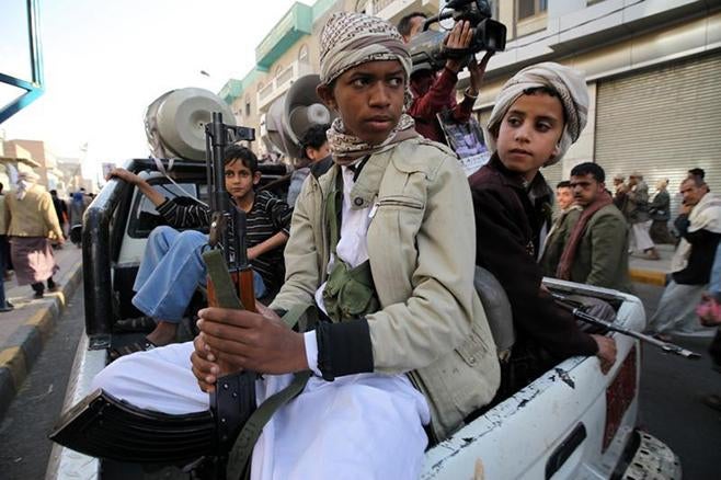 Child soldiers with Houthi fighters hold weapons during a demonstration in Sanaa on March 13, 2015.