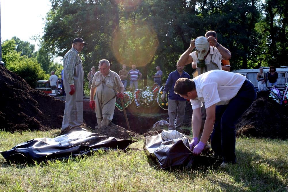 Workers at mass burial site putting bodies in bags in Sloviansk on July 24, 2014.