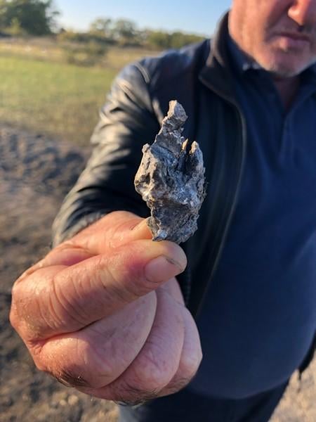 A resident of Ayrija village holds a fragment of the munition that killed a 16-year-old boy, Shahmaly Rahimov, on November 7, 2020.