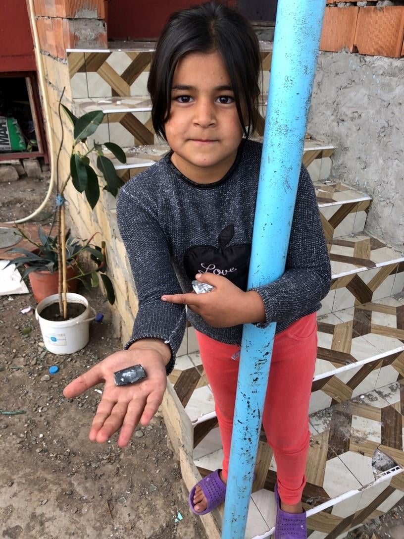 Nuray, 8, holds a fragment from a rocket artillery attack that destroyed her home and nine other homes in a residential neighborhood in Horadiz on October 7.