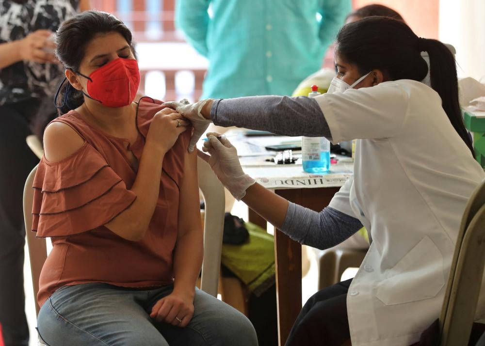 Une femme reçoit une injection du vaccin anti-Covid-19 d'Astra Zeneca, dans un immeuble d'appartements à Bangalore, en Inde, le 24 avril 2021.
