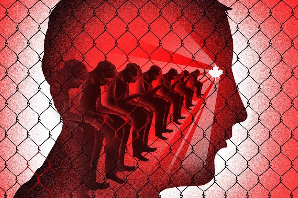 Image in shades of red with a fence in front of seated people.