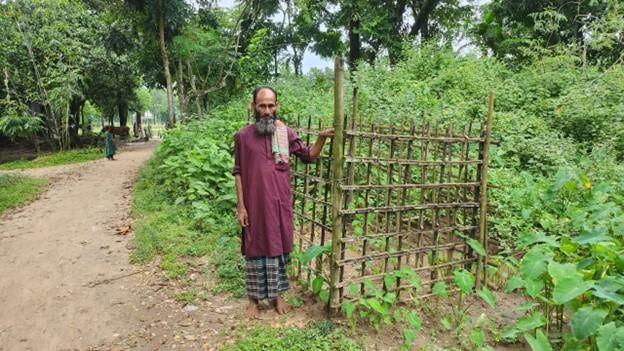 Mohammad Montaz Ali, un habitant de Bishwamvarpur (district de Sunamganj) au Bangladesh, photographié près du lieu de sépulture où est enterrée sa fille Taslima, décédée a 20 ans peu après les inondations de juin 2022. Cet homme a expliqué que Taslima, qui avait une déficience intellectuelle, est tombée dans une fosse inondée près d’une latrine extérieure, ce qui a fini par causer sa mort. 